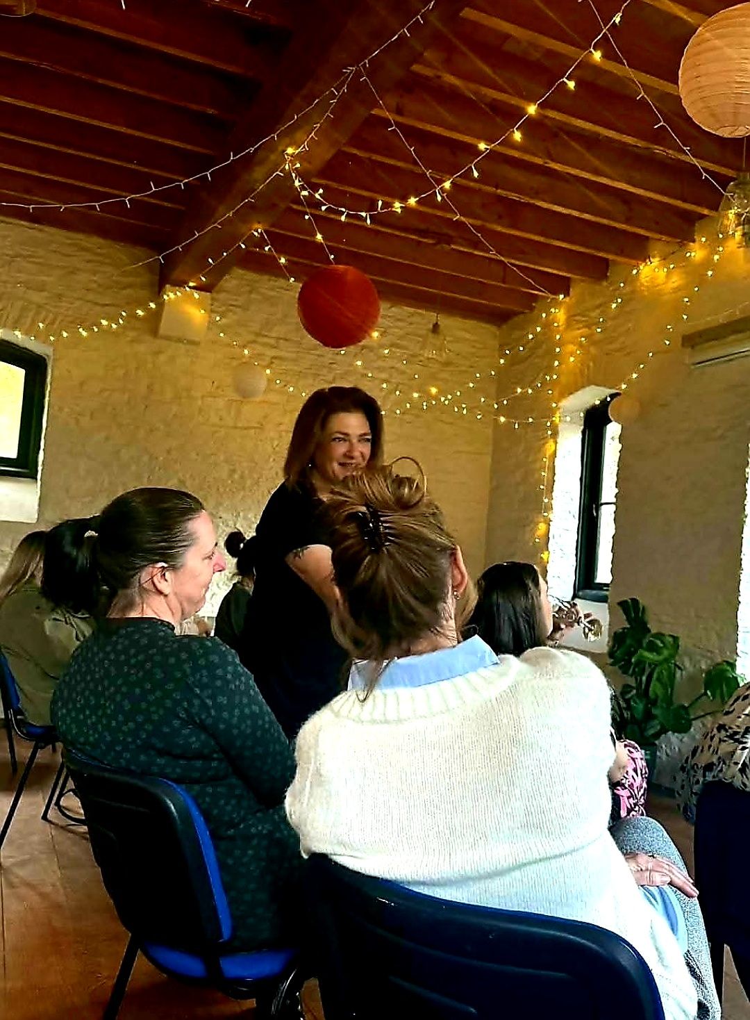 Nikki chatting with guests in the fairy-lit barn
