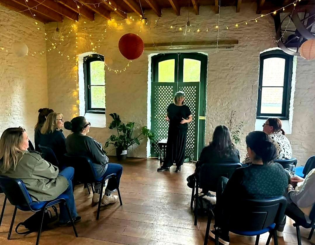 Nikki giving readings to a seated group in the barn