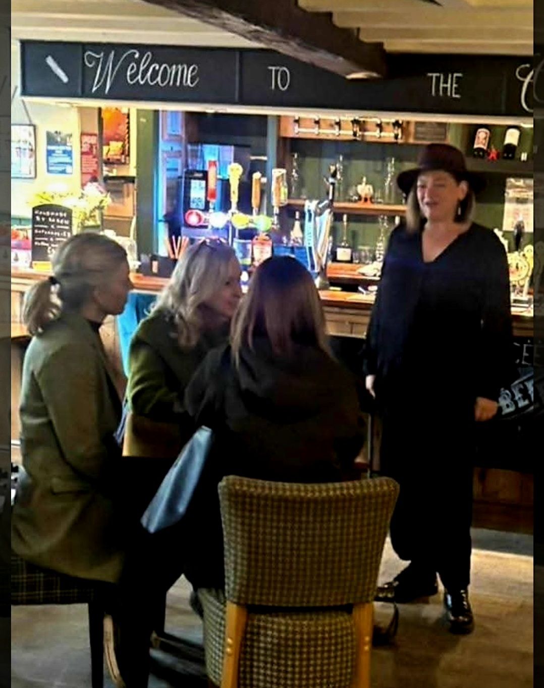 Nikki reading for a table of guests by the bar