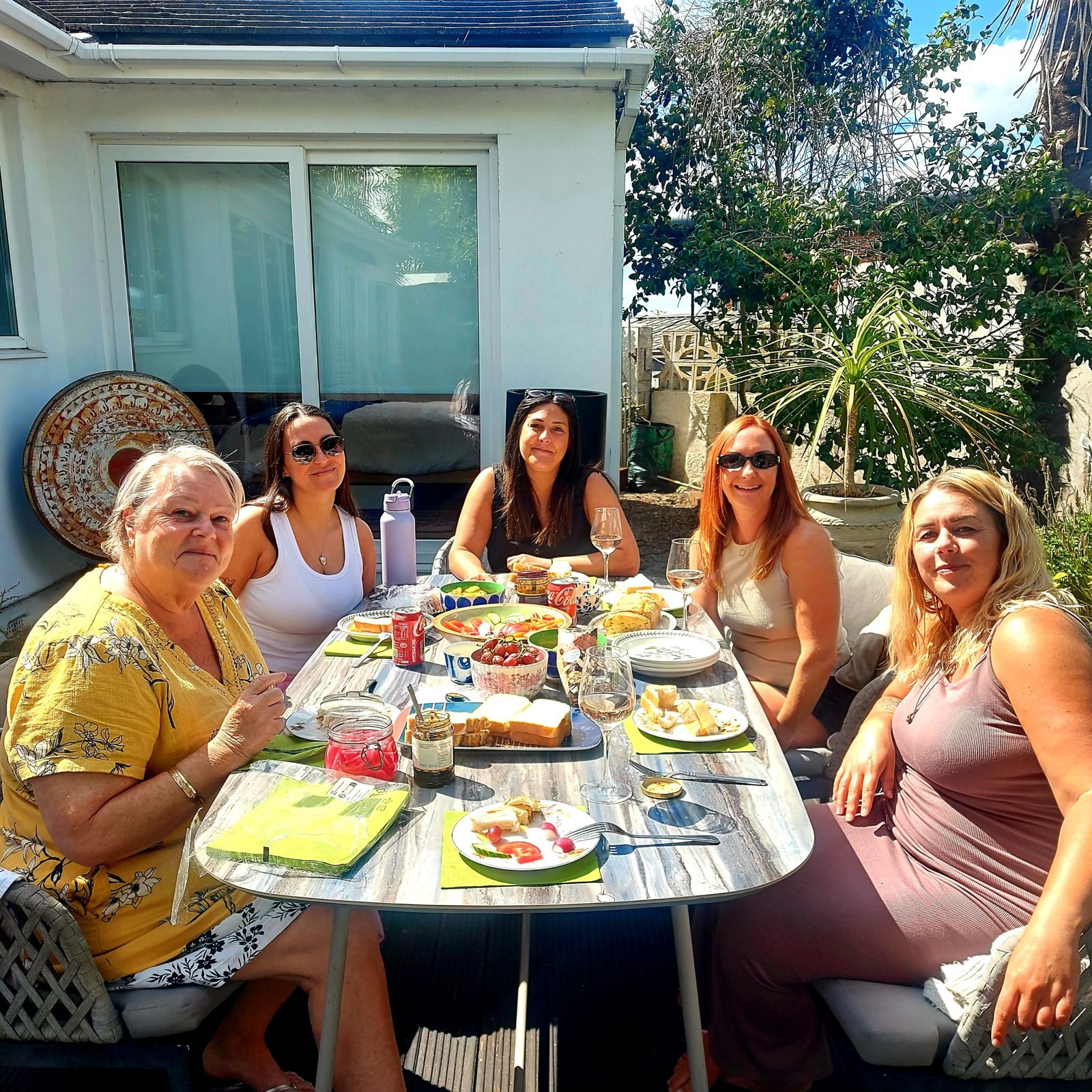 Friends sharing lunch in a sunny garden on a Friends therapy day